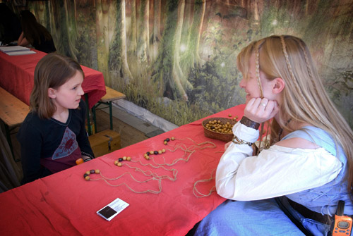 Les enfants apprennent à faire des Colliers des Âges.